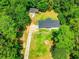 Aerial view of a home with a long driveway and spacious yard surrounded by lush trees at 5950 Central Church Rd, Douglasville, GA 30135