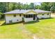 Expansive backyard featuring a screened-in porch, freshly cut green grass, and a white brick house at 5950 Central Church Rd, Douglasville, GA 30135