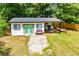 Backyard shed with a green door and open parking for a small boat and trailer at 5950 Central Church Rd, Douglasville, GA 30135