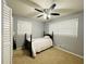 Neutral colored bedroom with a dark four-poster bed and a ceiling fan with lights at 5950 Central Church Rd, Douglasville, GA 30135