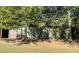 Wide shot of a metal storage container discreetly placed amidst lush trees on a grassy lot at 5950 Central Church Rd, Douglasville, GA 30135
