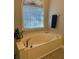 Relaxing bathroom features a jacuzzi tub, large window, neutral colors, and new fixtures at 10825 Pinewalk Forest Cir, Alpharetta, GA 30022
