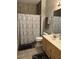 Bathroom features a shower with a curtain, gray flooring, oak cabinets, and double rugs at 10825 Pinewalk Forest Cir, Alpharetta, GA 30022