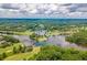 Expansive aerial view capturing the community's golf course, a quaint bridge across the lake, and surrounding verdant landscape at 2012 Golfers Way, Villa Rica, GA 30180