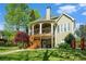 Back of home featuring spacious deck, manicured lawn, mature trees, and charming architectural details at 2012 Golfers Way, Villa Rica, GA 30180