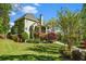 Back of home with spacious covered porch, manicured lawn, mature trees, and charming architectural details at 2012 Golfers Way, Villa Rica, GA 30180