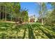 Expansive backyard with lush lawn, mature trees, pool, and charming pergola at 2012 Golfers Way, Villa Rica, GA 30180