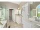 Bright bathroom features a large vanity with double sinks, soaking tub, and glass enclosed shower at 2012 Golfers Way, Villa Rica, GA 30180