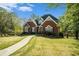 Charming brick home with a well-kept lawn, landscaped garden beds, and a stone walkway leading to the front door at 2012 Golfers Way, Villa Rica, GA 30180