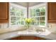 Close up of a well lit kitchen sink, faucet and countertop with outdoor view at 2012 Golfers Way, Villa Rica, GA 30180
