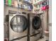 Laundry room with modern washer and dryer on pedestals and wire shelving at 2012 Golfers Way, Villa Rica, GA 30180