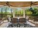 Covered porch featuring outdoor dining set, ceiling fans, view of yard, providing comfortable outdoor living at 2012 Golfers Way, Villa Rica, GA 30180