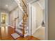Hardwood staircase with carpet runner to the upper levels features an open floorplan at 2012 Golfers Way, Villa Rica, GA 30180