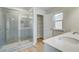 Modern bathroom with a glass-enclosed shower, double vanity, and tile flooring at 612 Leafy Branch Way, Mcdonough, GA 30253