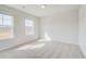 Bedroom with neutral walls and carpeting and windows overlooking the front of the home at 612 Leafy Branch Way, Mcdonough, GA 30253