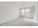 Bedroom with neutral walls and carpeting and windows overlooking the front of the home at 612 Leafy Branch Way, Mcdonough, GA 30253
