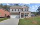 Charming two-story brick home featuring a two-car garage and manicured front lawn at 612 Leafy Branch Way, Mcdonough, GA 30253
