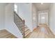 Hallway features hardwood floors, neutral walls, and access to staircase at 612 Leafy Branch Way, Mcdonough, GA 30253