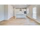 Bright kitchen features wood flooring, stainless steel appliances, white cabinets and a kitchen island at 612 Leafy Branch Way, Mcdonough, GA 30253