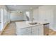 Bright kitchen island features stainless steel appliances and a sink with a view to the living room at 612 Leafy Branch Way, Mcdonough, GA 30253