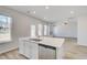 Bright kitchen island features stainless steel appliances and a sink with a view to the backyard at 612 Leafy Branch Way, Mcdonough, GA 30253