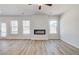 Open living room features hardwood floors, neutral walls, a fireplace, and natural light at 612 Leafy Branch Way, Mcdonough, GA 30253