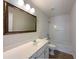 Bright bathroom with a decorative mirror, single sink vanity and shower-tub combo at 956 Buckhorn Bnd, Locust Grove, GA 30248