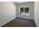 Cozy bedroom with a window letting in natural light, neutral-toned walls, and carpeted floors, perfect for relaxation at 956 Buckhorn Bnd, Locust Grove, GA 30248