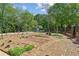 Backyard garden with brick-lined beds and a charming garden shed beyond a small iron fence at 1102 Emory St, Oxford, GA 30054