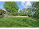 Lush backyard featuring expansive green space, mature trees, and a stone retaining wall at 1102 Emory St, Oxford, GA 30054