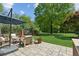 Lush backyard featuring a stone patio with comfortable seating and a well-maintained lawn at 1102 Emory St, Oxford, GA 30054