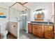 Bathroom featuring glass shower, vanity with wood cabinets, and decorative mirror at 1102 Emory St, Oxford, GA 30054