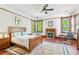 Bedroom with a wood frame bed, sitting area, fireplace, wood floors, and natural light at 1102 Emory St, Oxford, GA 30054