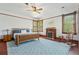 Bedroom with wood bedframe, sitting area, fireplace, wood floors, and natural light at 1102 Emory St, Oxford, GA 30054