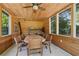Wood-paneled sunroom featuring a dining table, bunk beds, and many windows to the lush exterior at 1102 Emory St, Oxford, GA 30054
