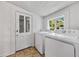 Well lit laundry room features washer and dryer with window, and door with windows at 1685 Carroll Nw Dr, Atlanta, GA 30318