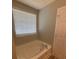 Bright bathroom featuring a clean white bathtub under a window with blinds at 2763 Storybook Ct, Grayson, GA 30017