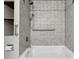 Detailed view of the bathroom's tiled shower and tub with a shower head and grab bar at 3024 Bob Cox Rd, Marietta, GA 30064