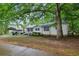 Traditional-style home with a carport, well-maintained lawn, and mature trees providing ample shade at 3024 Bob Cox Rd, Marietta, GA 30064