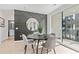 Modern dining space features gray accent wall with large round mirror and balcony access at 371 Grant Se Cir # 1822, Atlanta, GA 30315