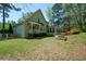 Charming home with a lush green lawn, inviting porch, and sunroom surrounded by colorful landscaping at 11050 Linbrook Ln, Duluth, GA 30097