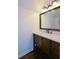 Bathroom featuring dark wood vanity with white countertop, mirror and hardwood floors at 11050 Linbrook Ln, Duluth, GA 30097