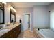 Large ensuite bathroom features a double granite vanity, a soaking tub, tile floors and a view of the walk-in shower at 11050 Linbrook Ln, Duluth, GA 30097