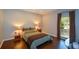 A cozy bedroom featuring hardwood floors, two lamps and side tables and natural light at 11050 Linbrook Ln, Duluth, GA 30097