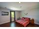 Bedroom with hardwood floors, a window with grey curtains, and an arrangement of furniture at 11050 Linbrook Ln, Duluth, GA 30097