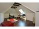Bright bonus room features a skylight, wood floors, and a vaulted ceiling with exposed beams at 11050 Linbrook Ln, Duluth, GA 30097
