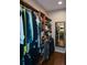 A view of a walk-in closet, with custom wood shelving, wood floors and a full length mirror on the back wall at 11050 Linbrook Ln, Duluth, GA 30097