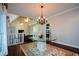 Elegant dining area with a glass table, hardwood floors, and decorative chandelier at 11050 Linbrook Ln, Duluth, GA 30097