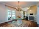 Dining room with hardwood floors, elegant chandelier, and a view to the vaulted living room at 11050 Linbrook Ln, Duluth, GA 30097