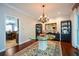 Dining room featuring an elegant chandelier, hardwood floors, and an adjacent kitchen at 11050 Linbrook Ln, Duluth, GA 30097